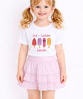 Young girl wearing a white t-shirt with ice cream graphics and text, standing against a plain background.