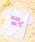 White t-shirt with pink 'Island Girl' text and palm tree graphic on a yellow background with flowers and lights.
