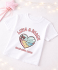 White t-shirt with a heart-shaped beach graphic and text on a light background