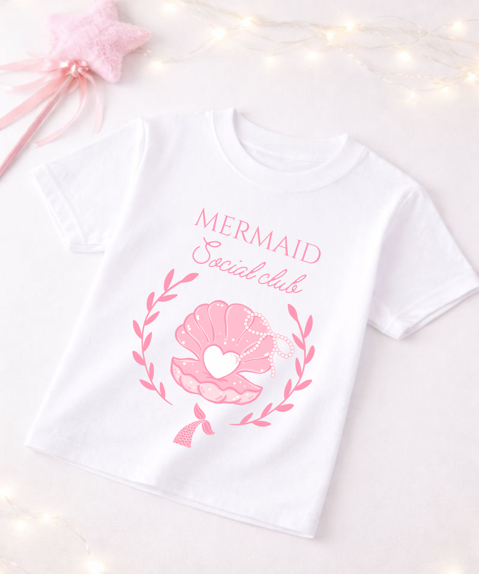 White t-shirt with pink mermaid-themed design on a white background